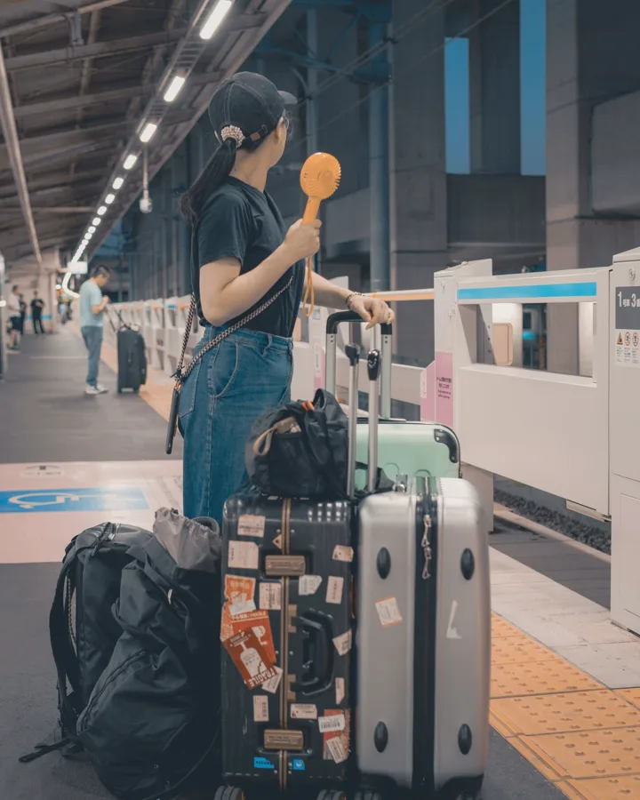 Viajera con maletas esperando en el andén